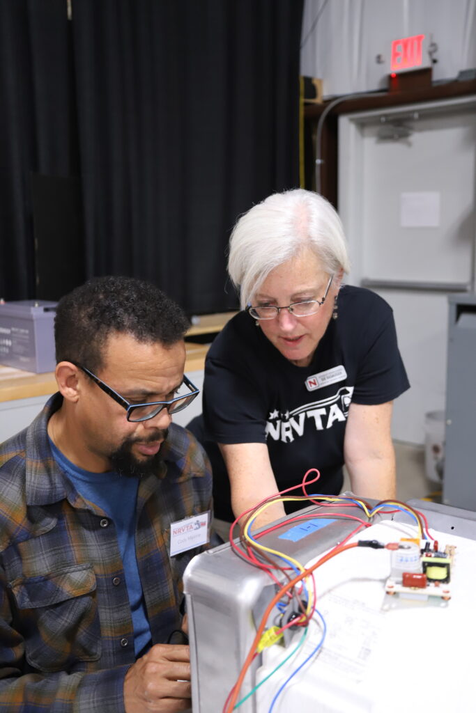 Susan Rasmussen teaching an NRVTA student hands on water heater troubleshooting
